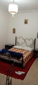 a bedroom with a bed and a red rug at Dar Kouzzou in Marrakech