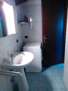 uma casa de banho com um lavatório branco e um WC. em Appartamento De Angeli em Laveno-Mombello
