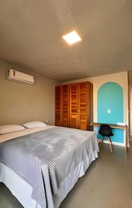 una camera da letto con un letto grande e una scrivania di Anfitrya - Casa 38 a São Miguel do Gostoso Altre 21 foto