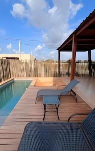 una piscina con panchina accanto a una terrazza in legno di Anfitrya - Casa 38 a São Miguel do Gostoso