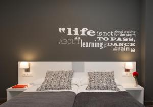 a bedroom with a bed with a writing on the wall at 08028 Apartments in Barcelona