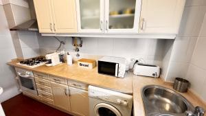 a kitchen counter with a sink and a microwave at Cabana Fersan in Cabanas de Tavira +15 photos