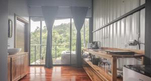 a kitchen with a counter and a large window at Arenal Hideaway in San Ramón