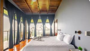 a bedroom with a bed and a large window at Arenal Hideaway in San Ramón