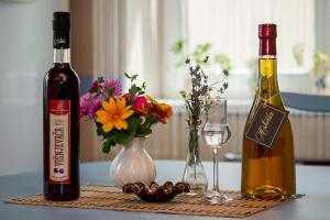 uma mesa com duas garrafas de vinho e flores em Guest House A'storia em Ruma