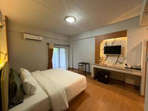 a bedroom with a bed and a desk with a television at BanPunmanus Hotel in Krabi