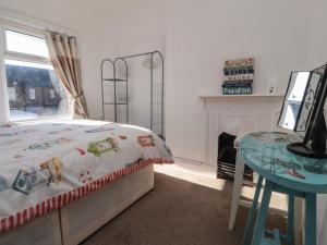 a bedroom with a bed and a table and a window at 23 Dock Road in Lytham St Annes