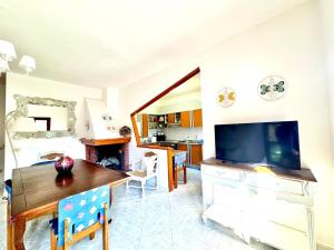 a living room with a dining table and a large television at Villa Prestige, Pula, Sardegna in Fort Village