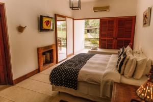 a bedroom with a large bed and a fireplace at Resort Fazenda 3 Pinheiros in Engenheiro Passos