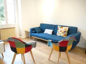 a living room with a blue couch and two chairs at Le Passage du Roi, maison de ville, jardin et garage au coeur d'Amboise in Amboise +23 photos