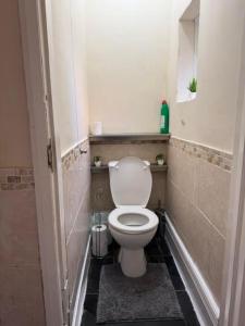 a small bathroom with a toilet in a stall at Cozy Haven Near Leicester University and General Hospital in Leicester