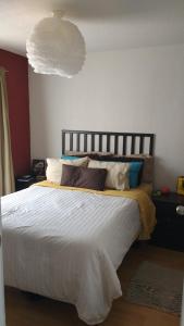 a bedroom with a large white bed with pillows at Acogedor departamento, Zona Norte in San José el Alto +3 photos