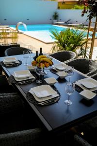 a table with a plate of fruit and wine glasses at Luxury Villa Experience in Center of Zadar with heated pool and Jacuzzi in Zadar