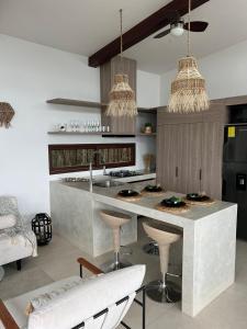 une cuisine avec un comptoir avec des tabourets et un évier dans l'établissement Casa Calmar, à Ayampe