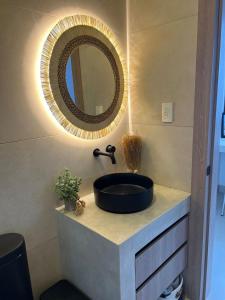 une salle de bain avec un lavabo noir et un miroir dans l'établissement Casa Calmar, à Ayampe