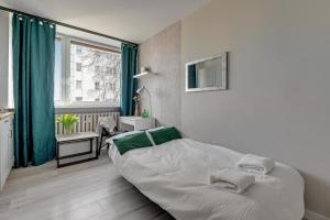 a white bedroom with a bed and a window at Gdynia Campus in Gdynia