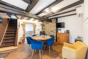 a dining room with a table and blue chairs at Gîte "L'Escale du Vignoble" à Ribeauville in Ribeauvillé