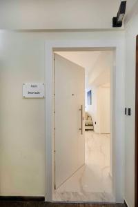 Una puerta abierta en una habitación con una pared blanca. en Kallimarmaro MM Smart suite by SuperHost Hub, en Atenas