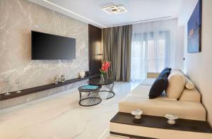 Una sala de estar con un sofá y un televisor de pantalla plana. en Kallimarmaro MM Smart suite by SuperHost Hub, en Atenas