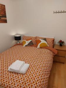 a bed with a white towel on top of it at The Galaxy in Wokingham