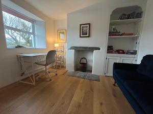 a living room with a table and a fireplace at 1 Rock Cottages in Treknow +29 photos