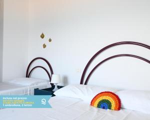 a rainbow pillow sitting on top of a bed at RS323 - Marcelli, bilocale fronte mare con spiaggia inclusa in Marcelli