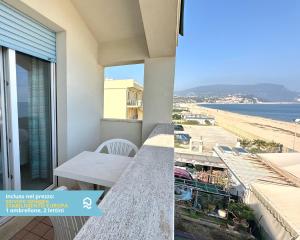 a balcony with a table and a view of the beach at RS323 - Marcelli, bilocale fronte mare con spiaggia inclusa in Marcelli