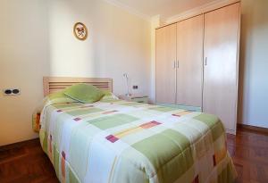 une chambre avec un grand lit et une armoire dans l'établissement Apartamentos de playa en Villajuán, à Vilagarcía de Arousa