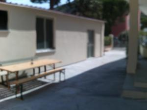 un banco de madera sentado frente a un edificio en Nina Casa Vacanze, en Finale Ligure