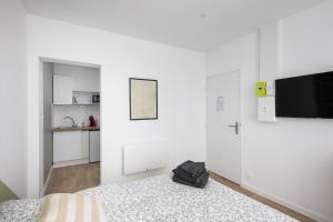Cette chambre blanche dispose d'un lit et d'une télévision à écran plat. dans l'établissement Friskette, à Brest