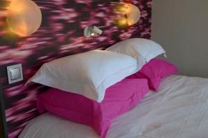 a bedroom with a bed with pink and white pillows at Le Clos Du Lac - location de chambres in Veyrier-du-Lac