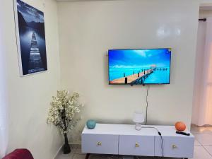 a living room with a tv hanging on a wall at S&R Home appartement in Yaoundé