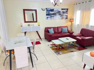 a living room with a red couch and a table at S&R Home appartement in Yaoundé