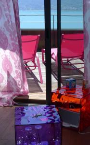 a view of a deck with pink chairs and a table at Le Clos Du Lac - location de chambres in Veyrier-du-Lac