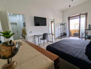 una camera da letto con un letto, un tavolo e una televisione di The Palm Leaf ad Alghero
