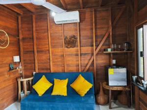 a blue couch with yellow pillows in a room at Rustika in Holbox Island