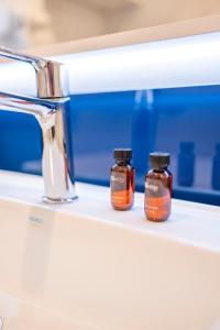 three bottles of medicine sitting on a shelf next to a sink at Orbi City Hotel D1 Block in Batumi +42 photos