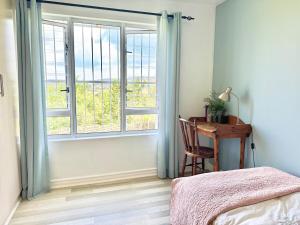 Un dormitorio con una cama y un escritorio y una ventana. en Tranquil Sunsets, en Equestria 20 fotos más