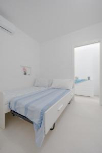 a white bedroom with a bed and a window at Lulu Apartament in Civitanova Marche