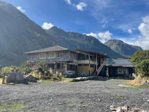 a house in a field with mountains in the background at SOL DE PIEDRA in Papallacta