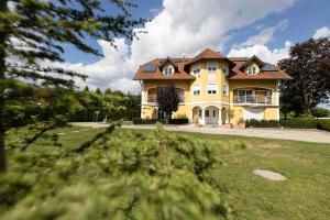 a large yellow house with a brown roof at Parkvilla 11 in Fürstenfeld
