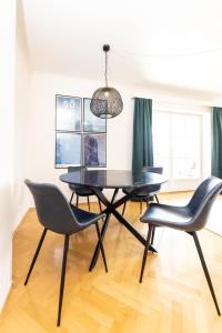 a dining room with a black table and chairs at Parkvilla 11 in Fürstenfeld