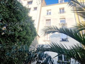 a building with a palm tree in front of a building at Marine 4 in Cherbourg en Cotentin