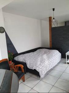 a bedroom with a bed and a table and chairs at Agréable maisonnette in Moranville