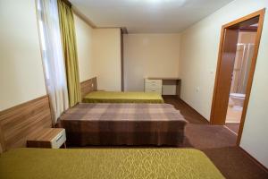 a room with two beds and a mirror at Ski Chalets at Pamporovo - an affordable village holiday for families or groups in Pamporovo