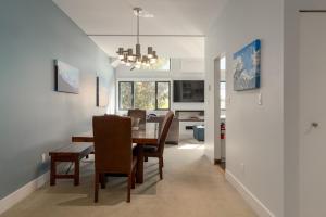 Un comedor y una sala de estar con mesa y sillas. en Tantalus Penthouse Mountain and Village Views, en Whistler