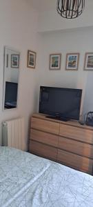 a bedroom with a flat screen tv on a dresser at Grand studio Sophie rénové avec goût Wi-Fi balcon parking 50m des cures in Amélie-les-Bains-Palalda