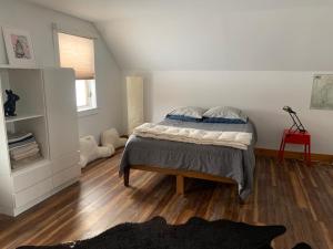 a bedroom with a bed and a wooden floor at Charming barn loft - all amenities on 60 acre farm in the White Mountains of NH in Lancaster