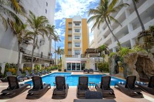 a hotel pool with lounge chairs and palm trees at Best Western Hotel Posada Freeman Zona Dorada in Mazatlán