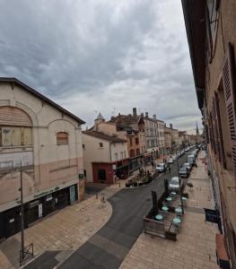 a city street with cars parked on the side of the road at Le Nid Urbain in Villefranche-sur-Saône